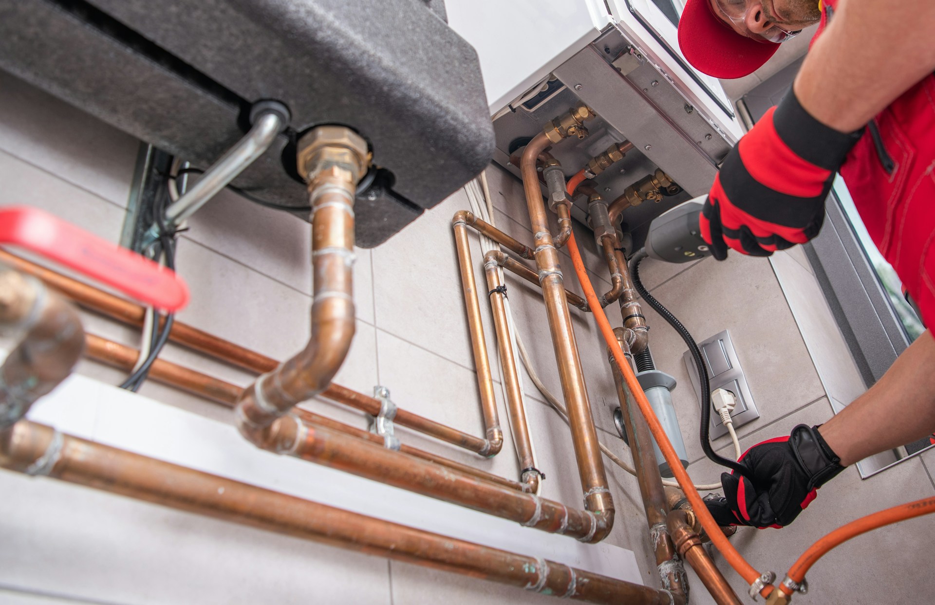 Plumber working on pipes while a phone call goes unanswered